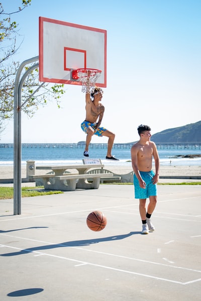 两个男人白天在篮球场上打篮球